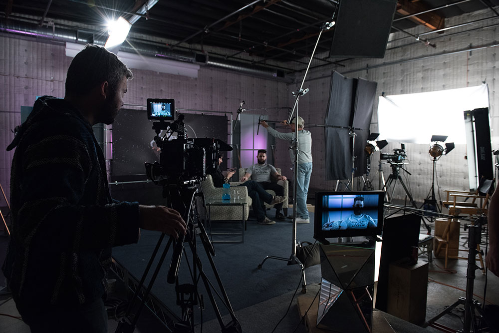 man with camera filming a scene